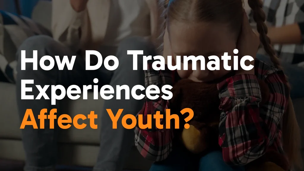 A young girl sits on a couch hugging a stuffed animal, covering her ears and looking distressed. The text over the image reads, How Do Traumatic Experiences Affect Youth?.